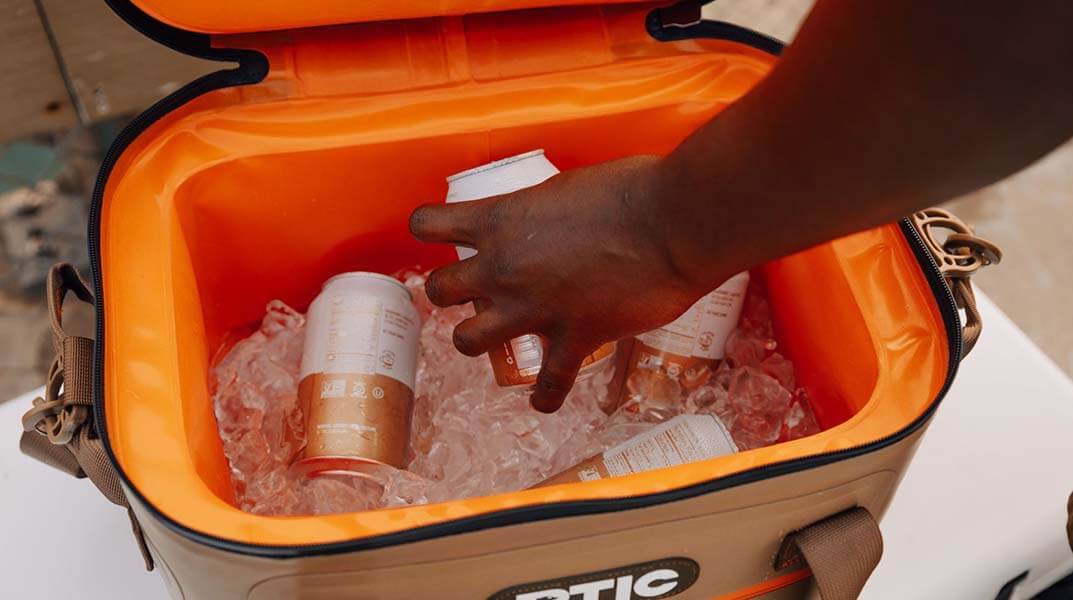 A hand reached into an RTIC cooler, Father's Day Gift Ideas. 