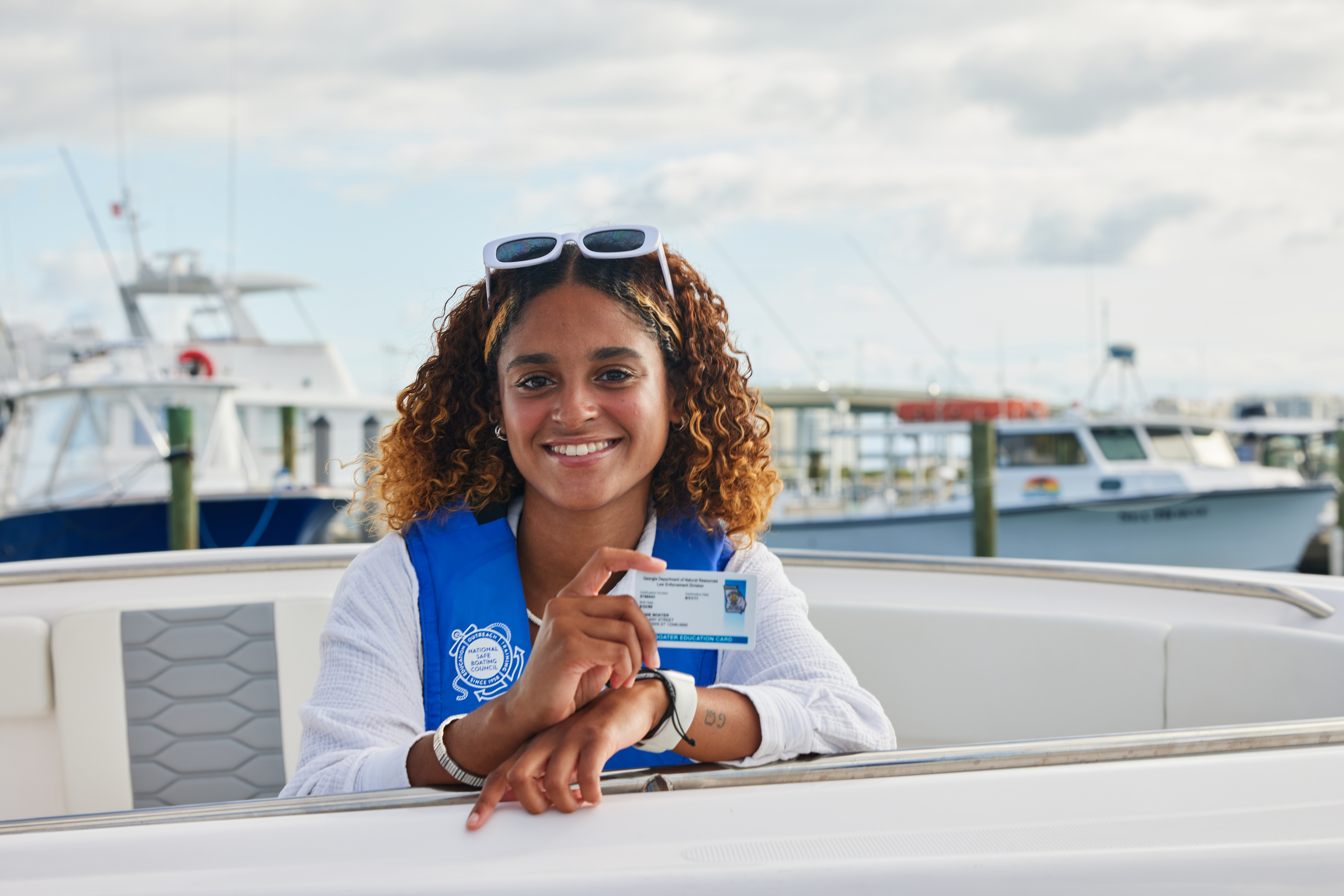 A woman holding a boater safety card, learn about rip currents concept. 