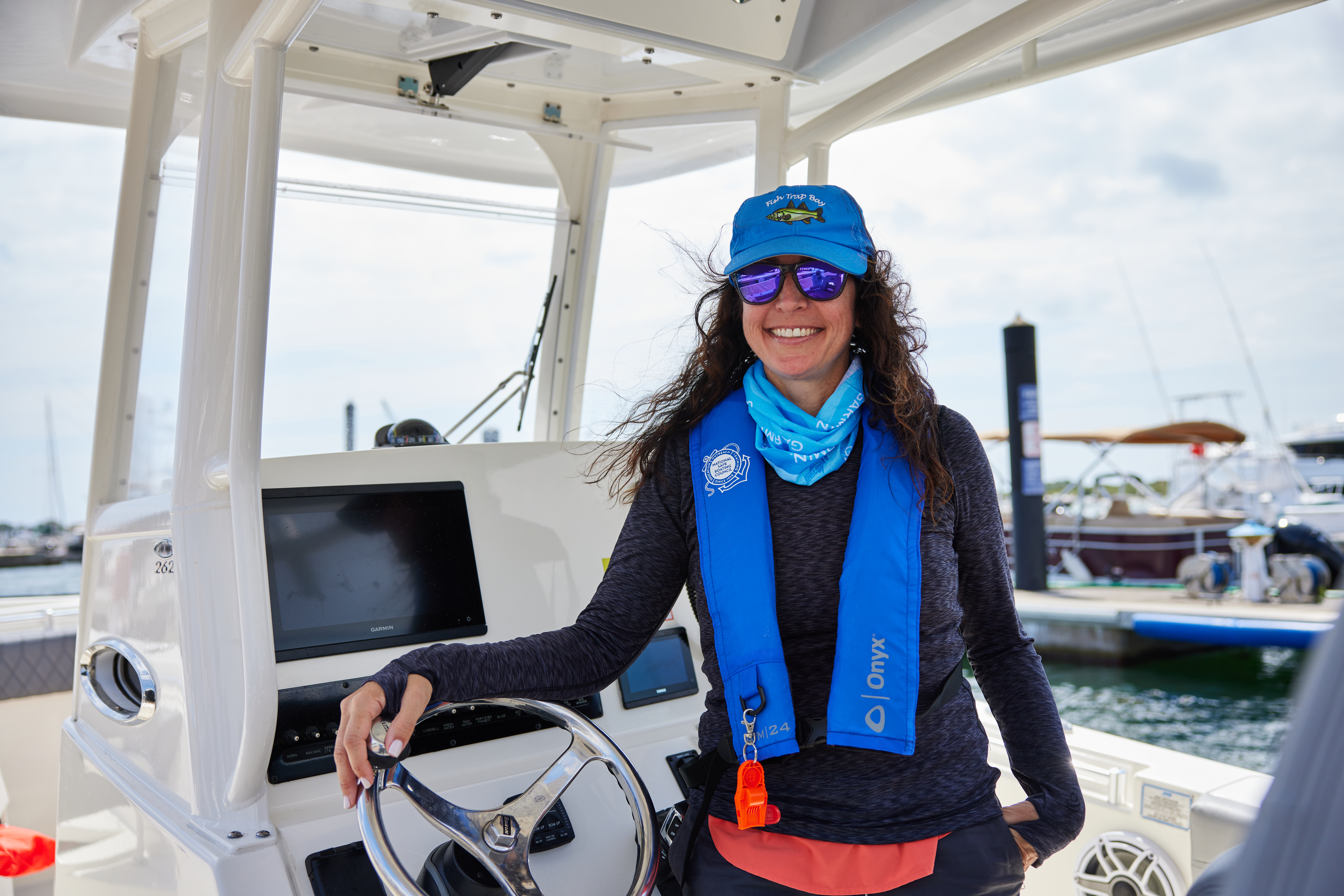 A smiling woman on a boat wearing a lifejacket, understanding boat anchors and safety concept. 