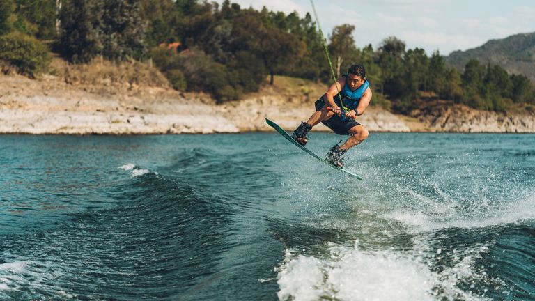 A man on a water ski jumping a wake, skiing and watersports safety concept. 
