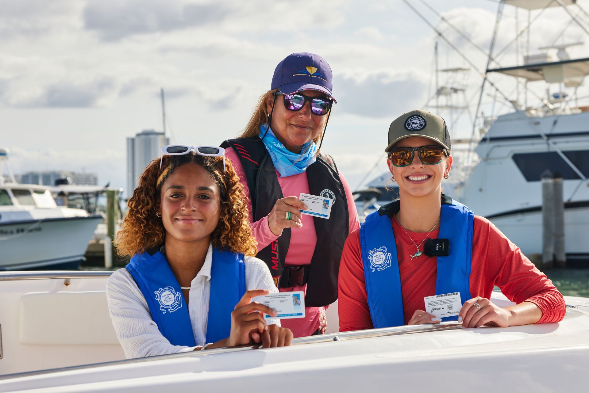 The women smiling and holding boater education cards, boating safety concept. 