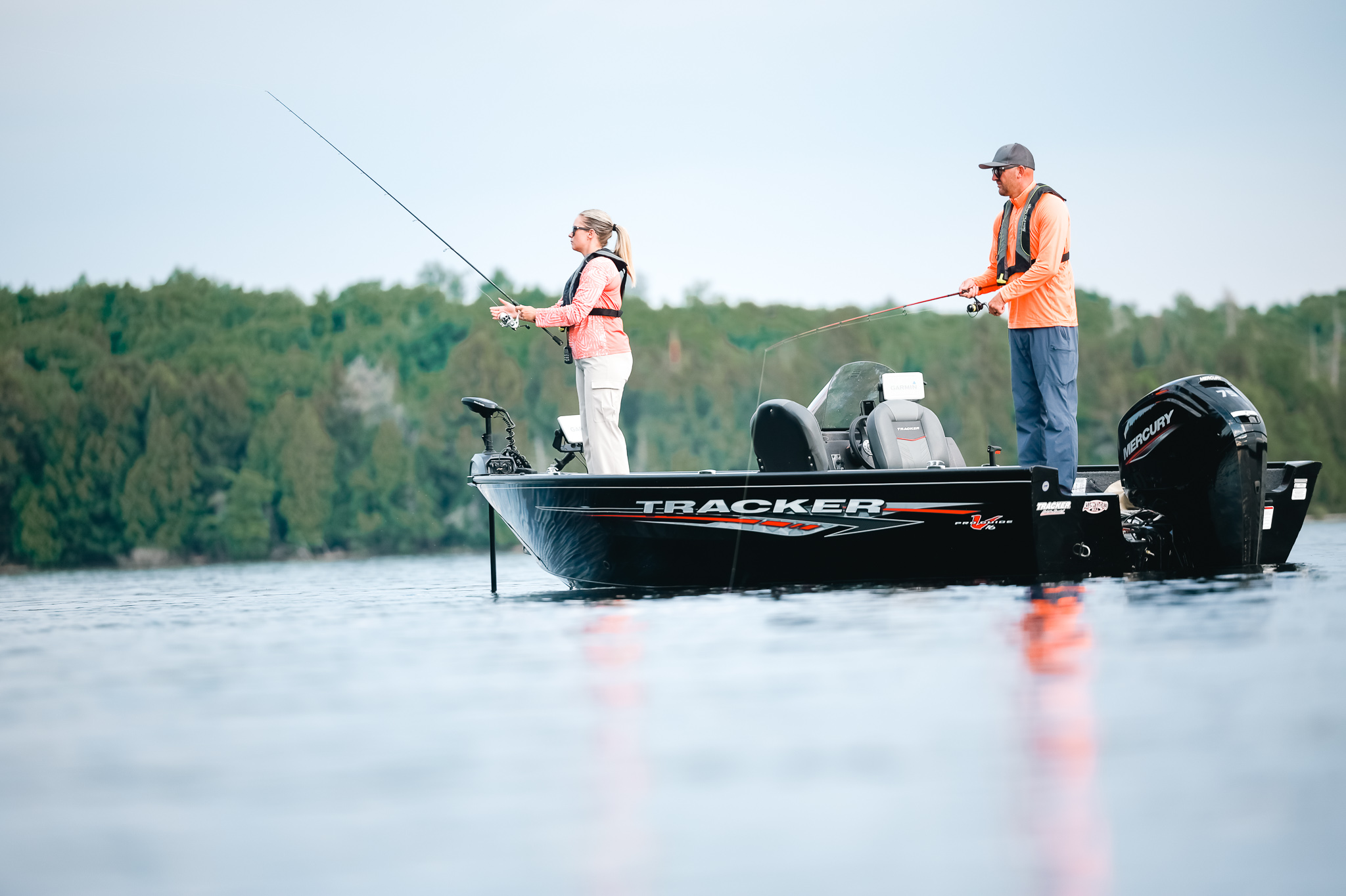 A man and woman fishing from a boat. 