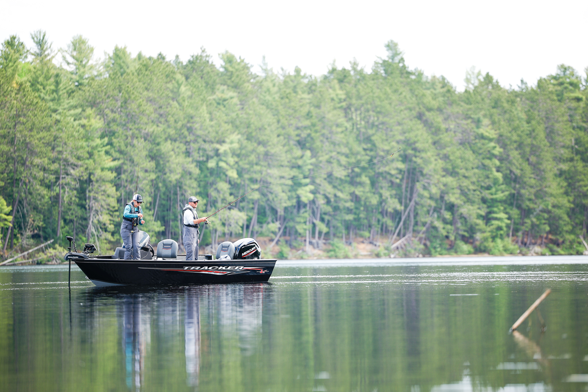 Two people standing in a boat while fishing, staying safe when using Ned rigs concept. 