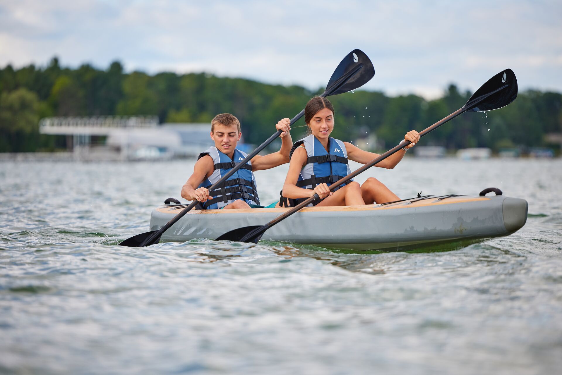 A girl and boy paddle a canoe, do you need a Sask boating license concept. 