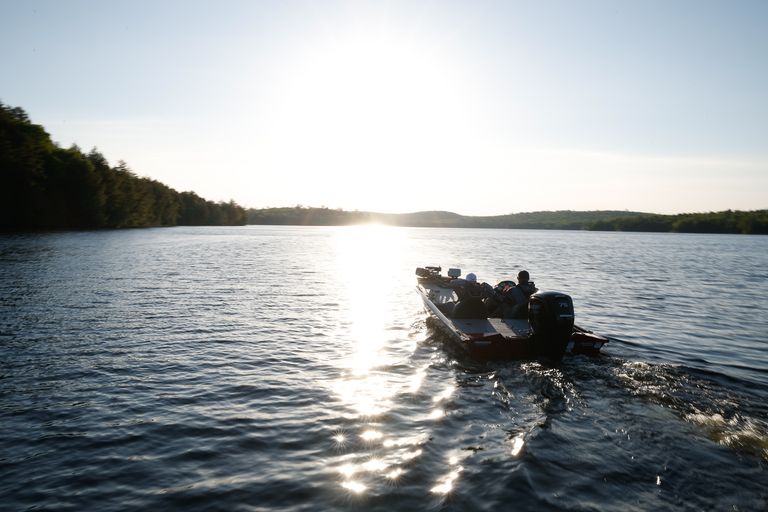 A person relaxing on a boat on the water at dusk, get a boat license concept. 