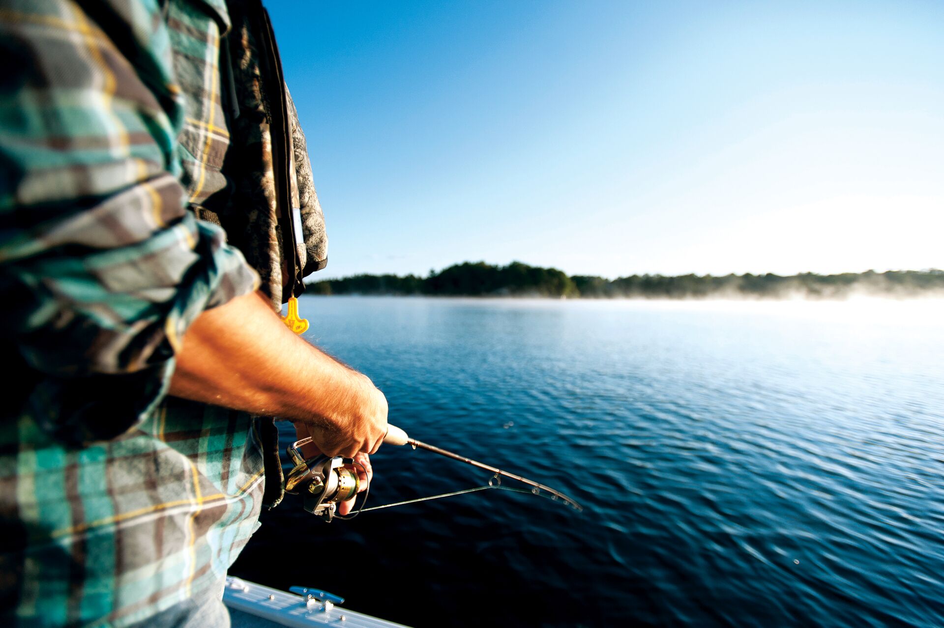 A man fishing from a boat. 