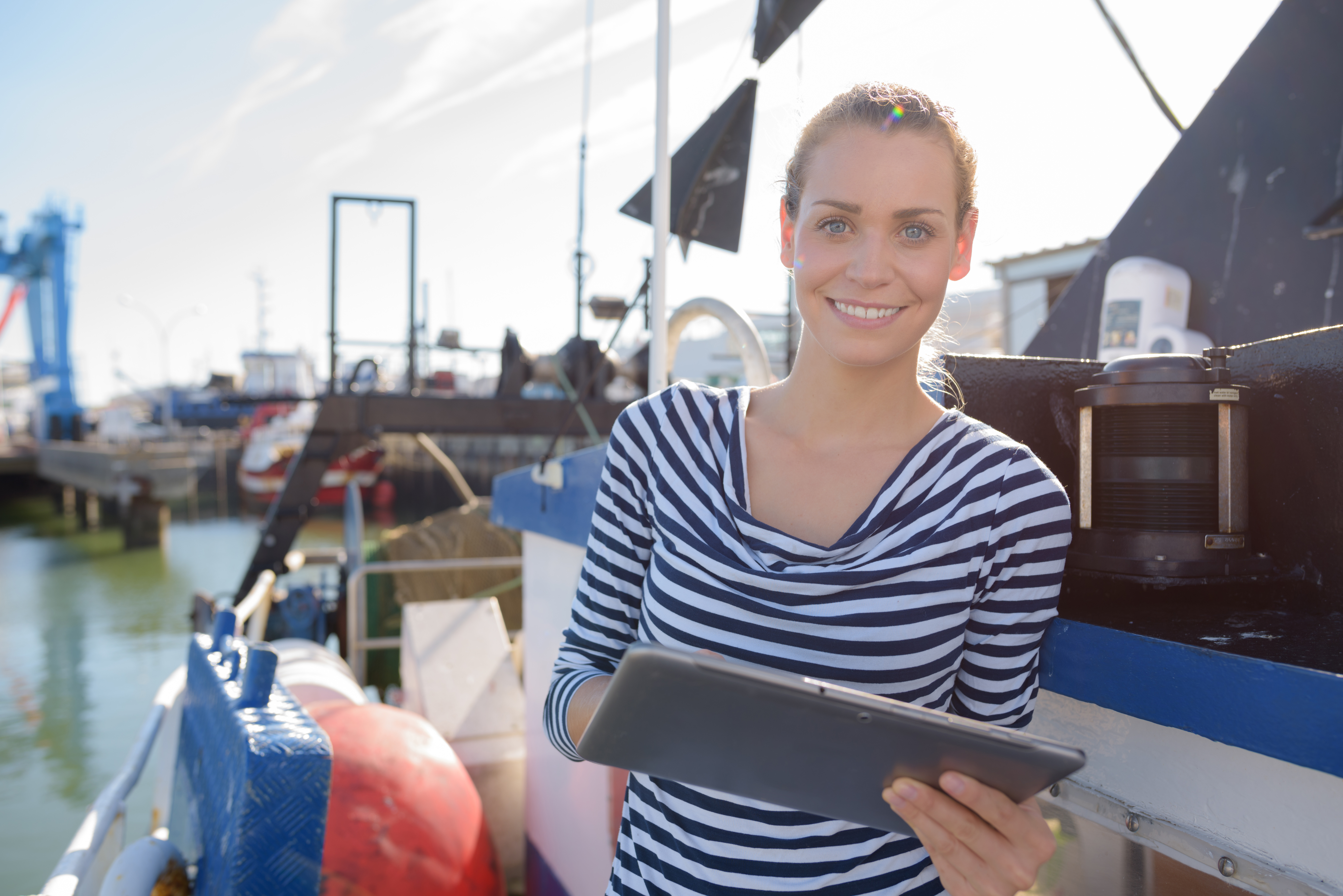 A woman on a boat holding a clipboard, boating license laws concept. 