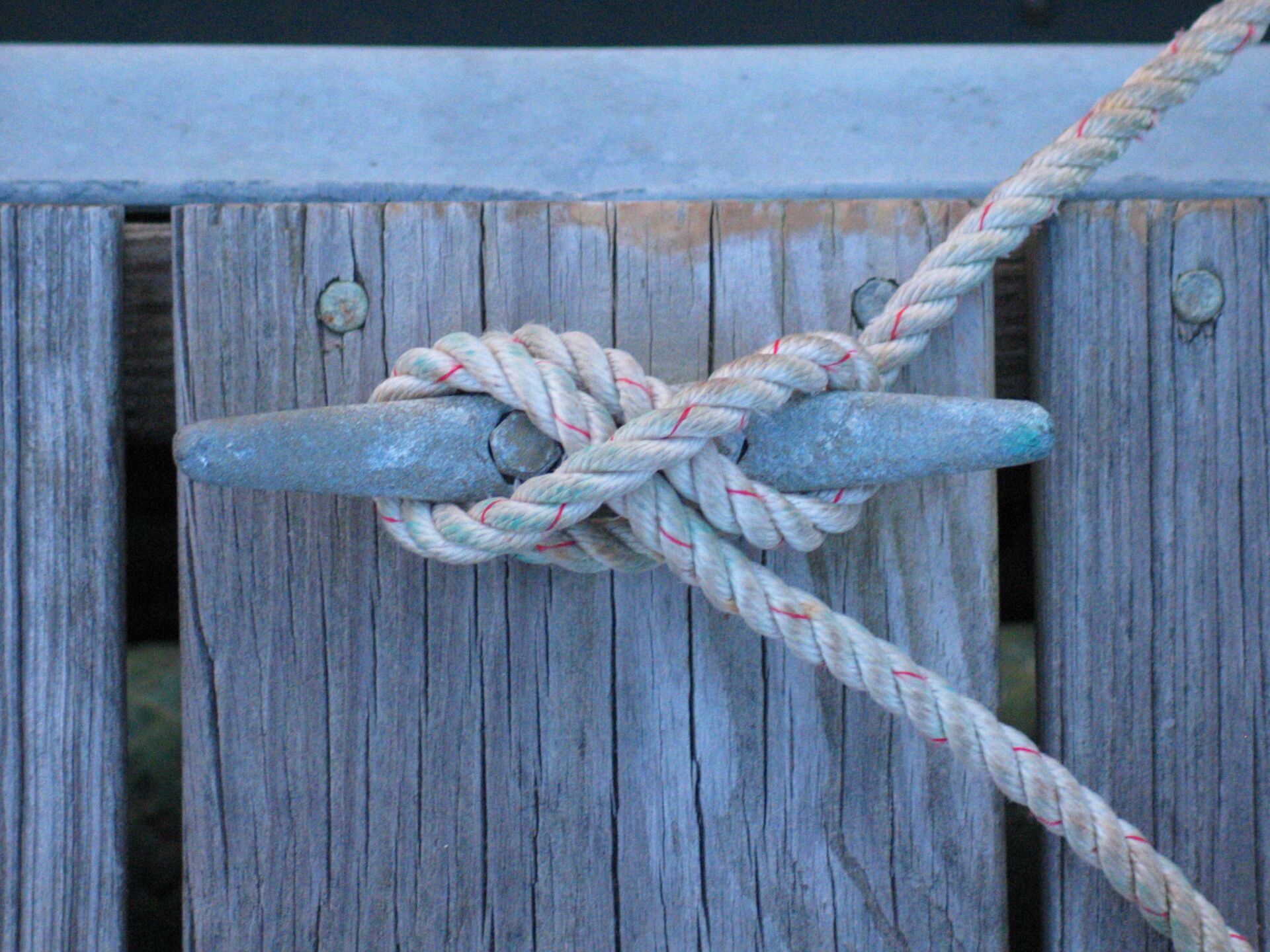 A cleat hitch knot tied to a cleat on a dock. 