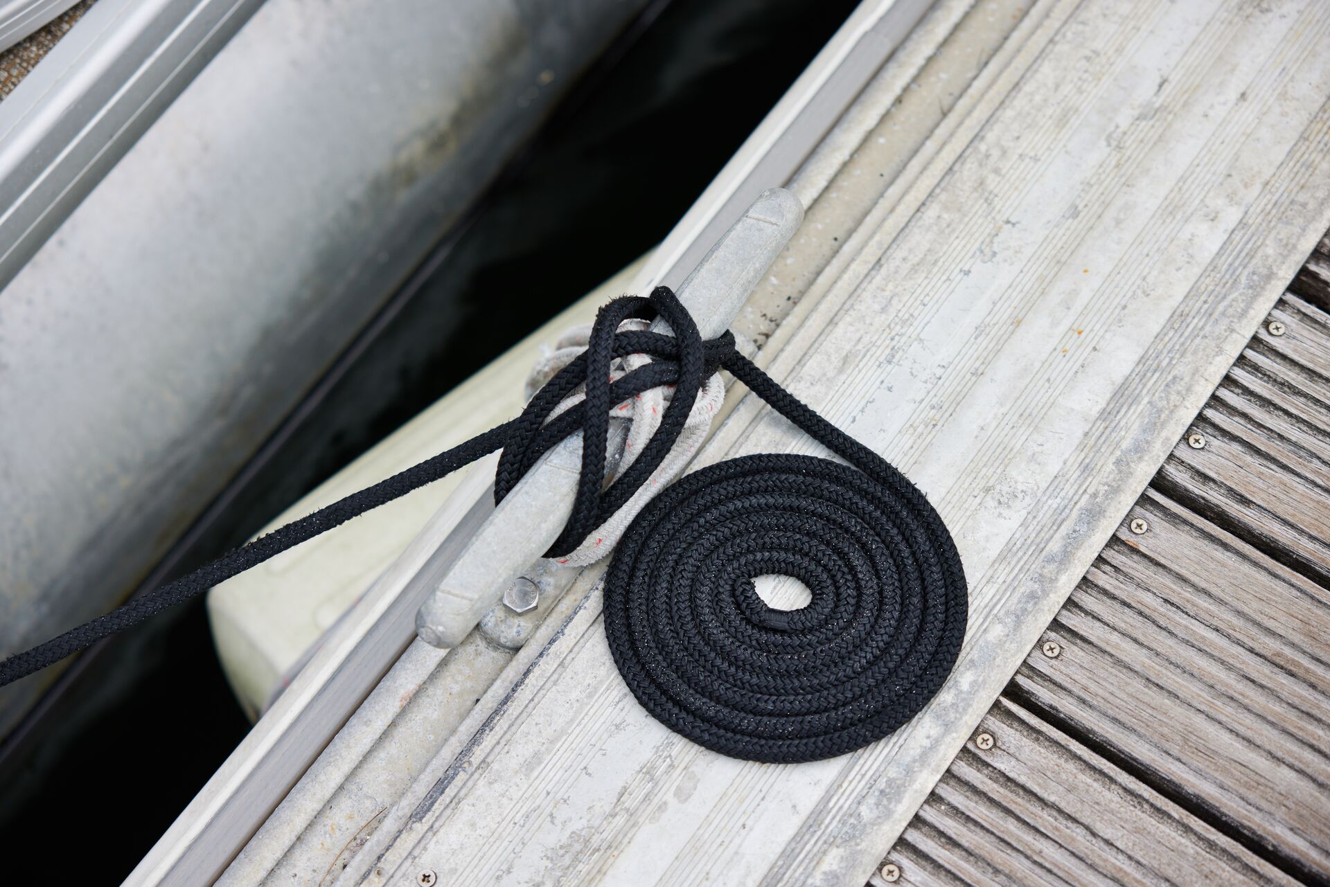 A rope and knot tied to a cleat on a dock, types of knots concept. 