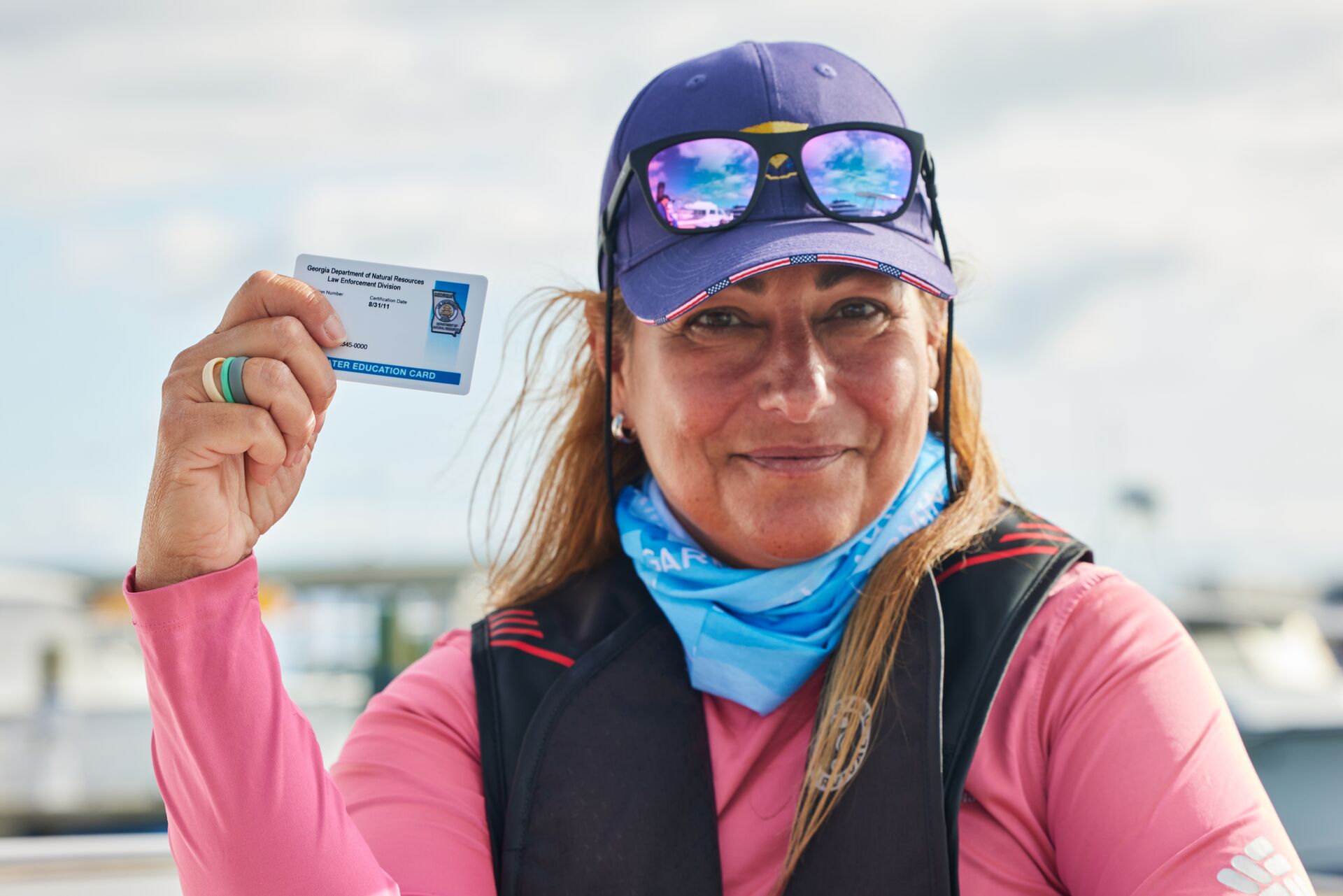 A smiling woman with a boater education card. 