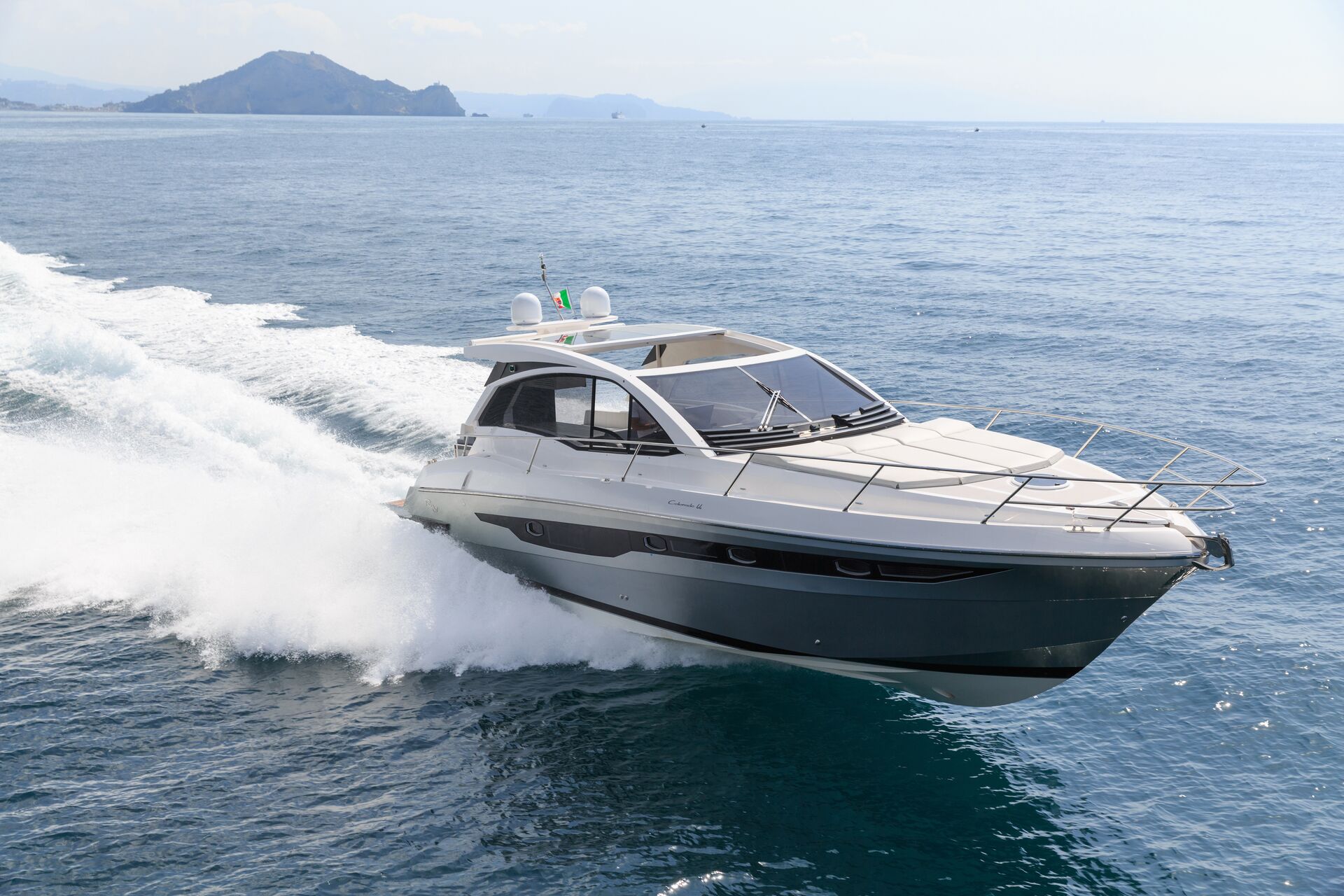 A luxury boat driving quickly on the water. 