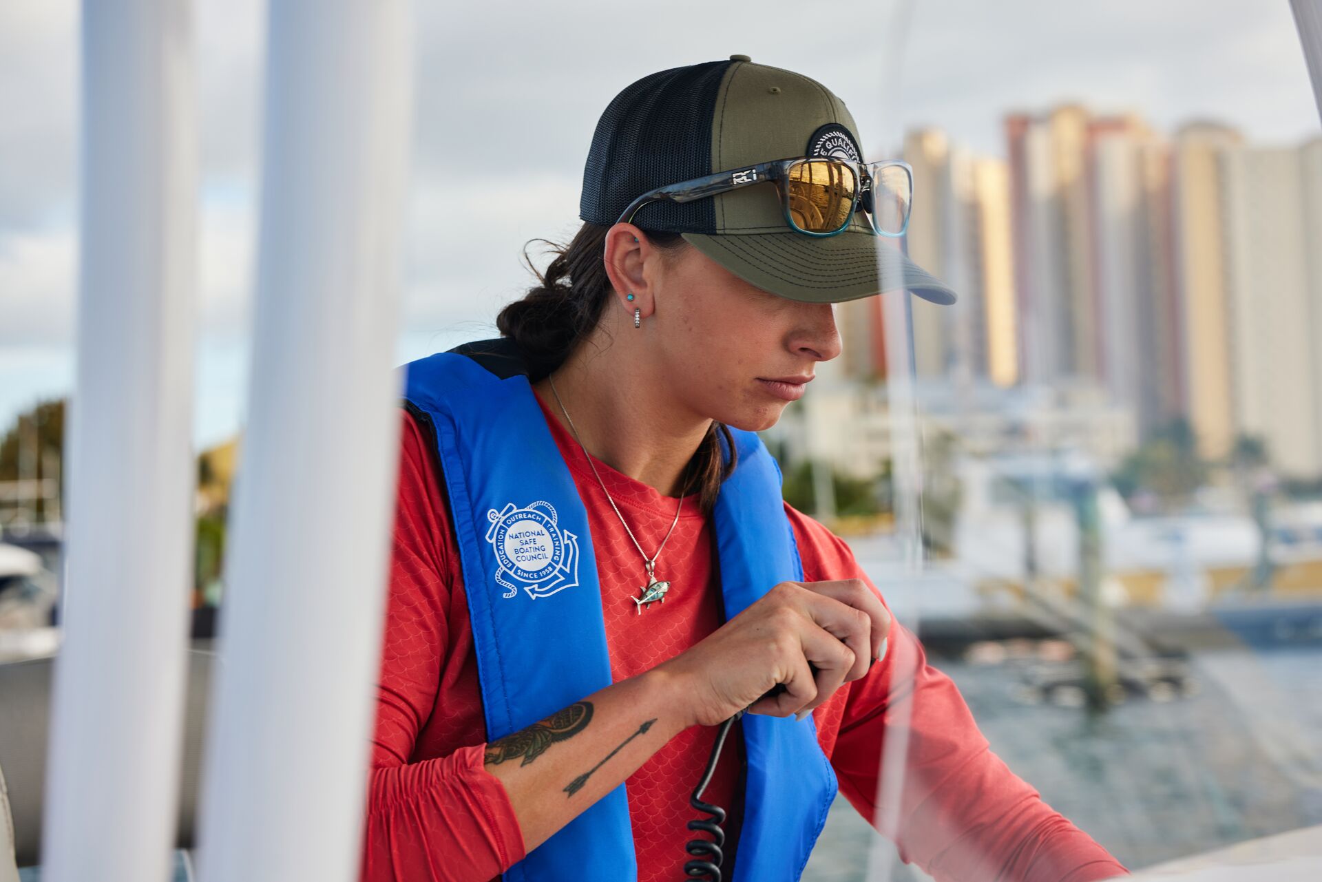 A woman uses a radio on a boat, what safety equipment is required on a boat concept. 