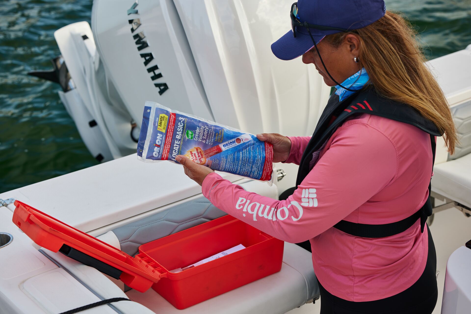 A woman looks at a box with boating safety equipment. 