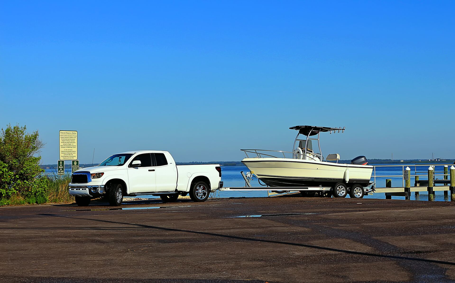 Truck with boat on a trailer parked near ramp. 