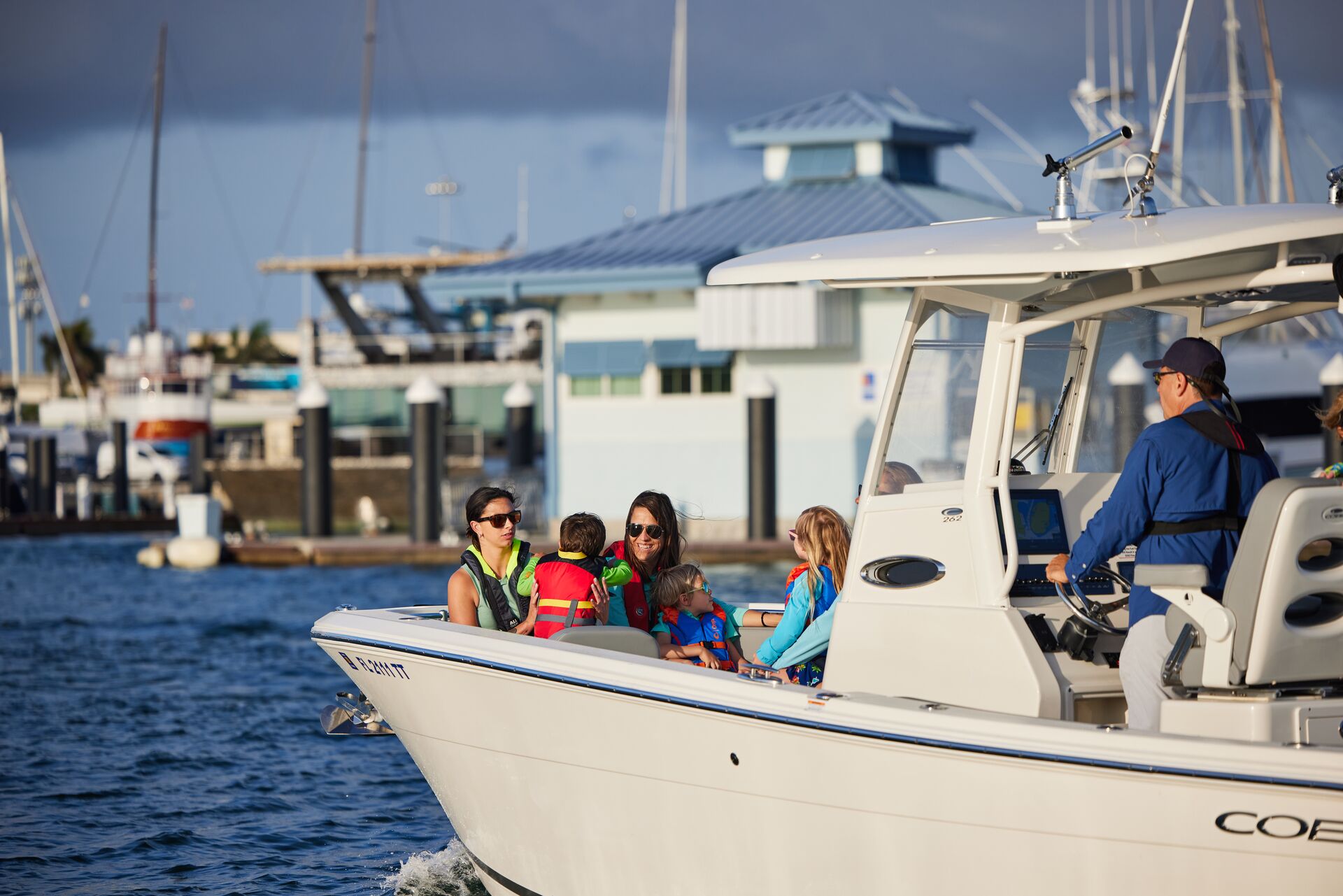 People in life jackets enjoying a center console boat on the water. 