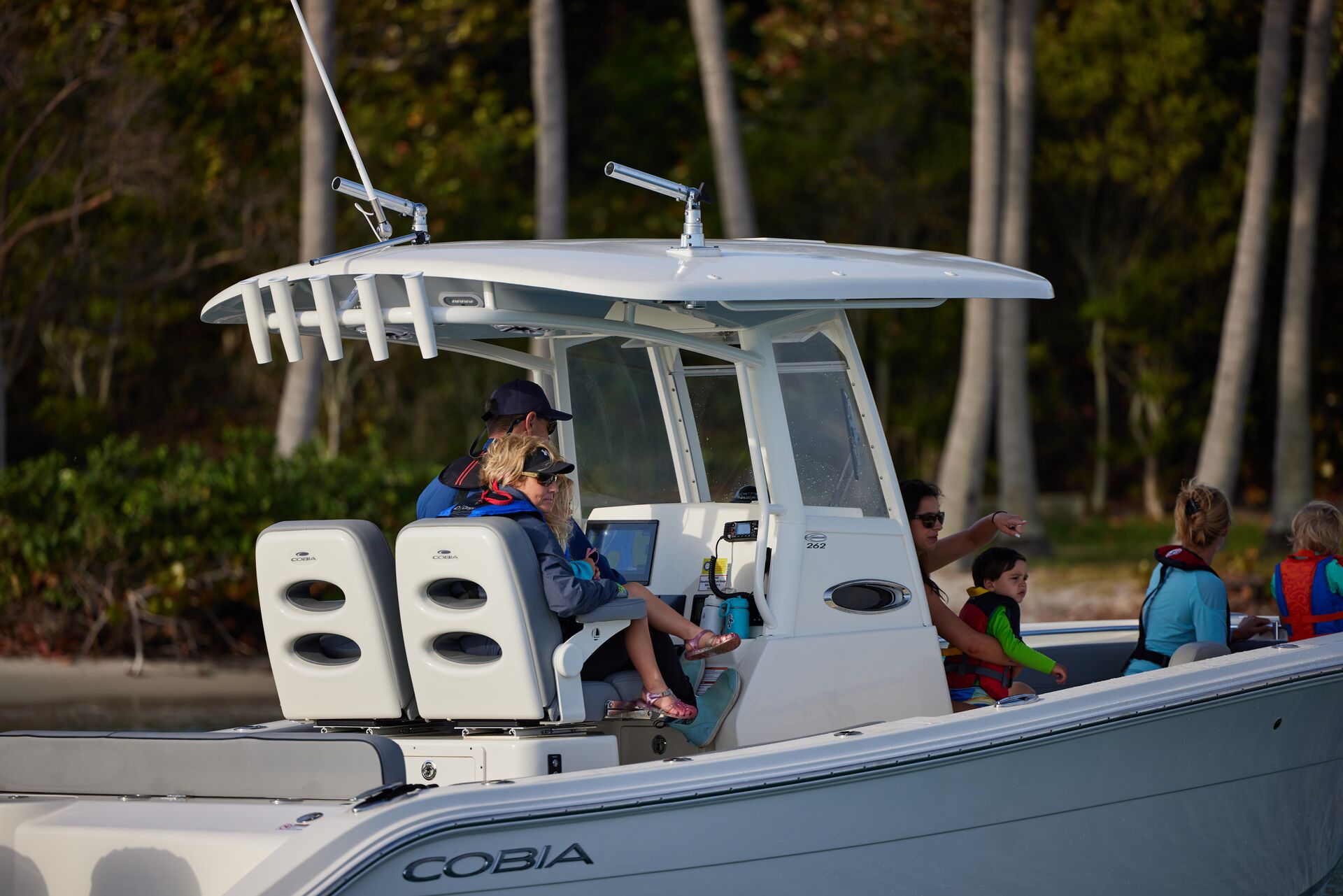 People in life jackets enjoying a boat on the water. 