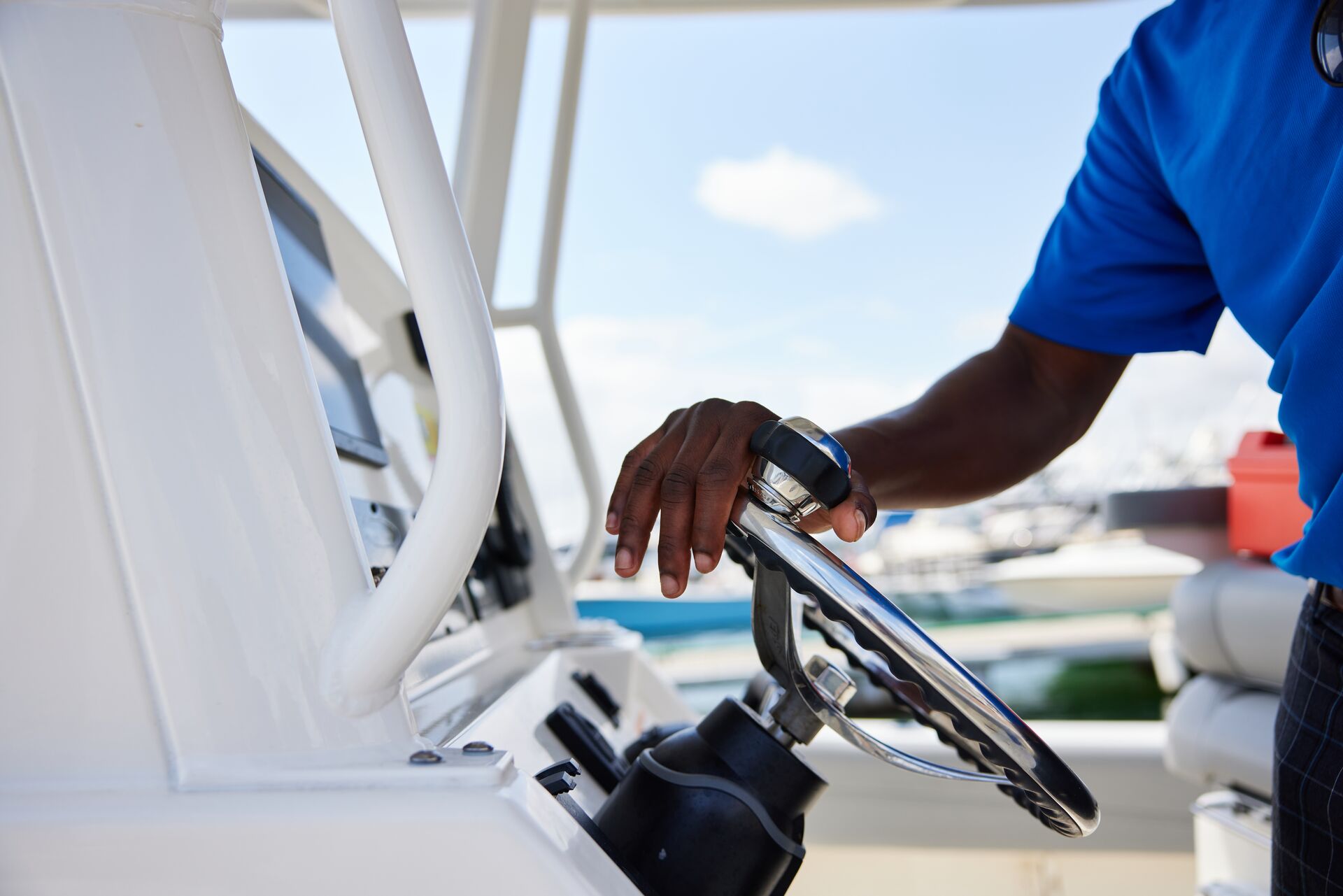 A man's hand on the steering wheel of a boat, parts of boats terminology concept. 