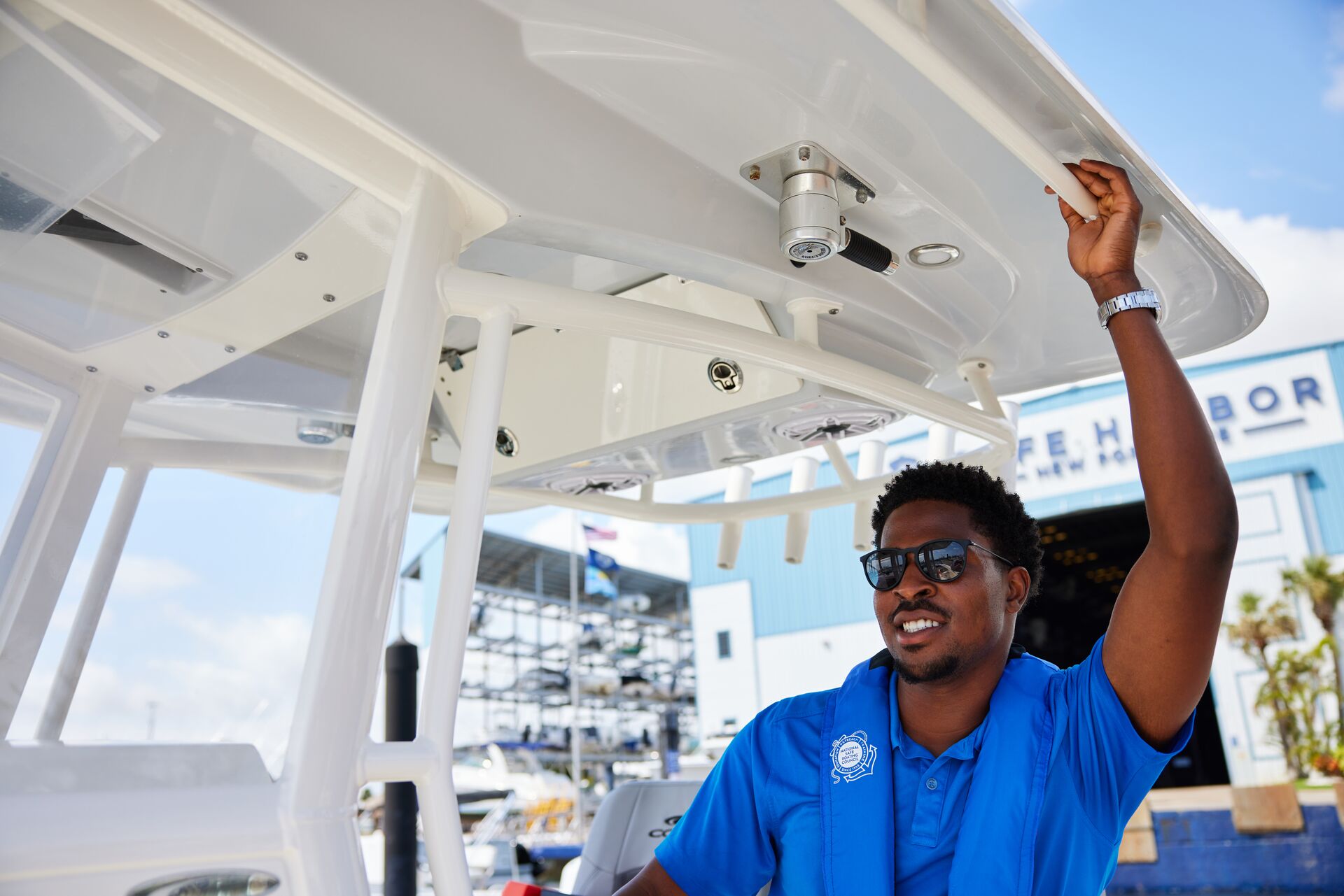 Man drives a boat while wearing blue life vest, who is exempt from California boating license concept. 